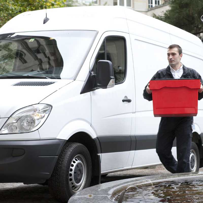 White delivery van with man delivering a red box