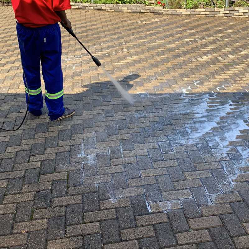 Man jet washing driveway